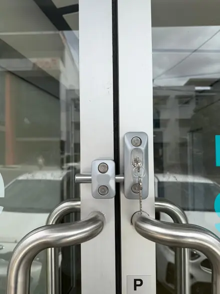 ADI security bolt lock installation on a commercial glass door